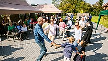 Menschen tanzen fröhlich im Kreis